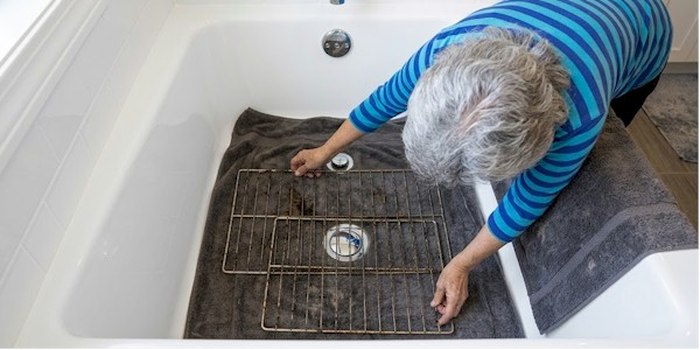 Anisa cleaning a bathtub drain